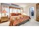 Spacious bedroom featuring a king-size bed, decorative pillows, and elegant curtains at 1400 Colony Pl, Venice, FL 34292