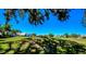 View of golf course and mature landscaping with homes in the background at 1400 Colony Pl, Venice, FL 34292