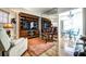 Warm living room with built-in entertainment center, access to the dining area, and hardwood flooring at 1400 Colony Pl, Venice, FL 34292