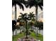 Charming street view with flowering baskets on lamp posts, framed by tall palm trees and lush greenery at 1400 Colony Pl, Venice, FL 34292