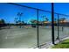 Well-maintained tennis courts at Waterford, featuring a net, lighting, and fencing for a complete recreational facility at 1400 Colony Pl, Venice, FL 34292