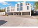 Modern townhouse complex with parking garage and sleek white facade under a bright blue sky at 1558 4Th St # 208, Sarasota, FL 34236