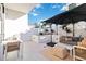 This patio features an outdoor dining area with a table, chairs, and umbrella, and a sofa with throw pillows at 1558 4Th St # 208, Sarasota, FL 34236