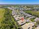 Aerial view showcasing a residential neighborhood nestled among mature trees, lakes, and a verdant golf course at 1567 Monarch Dr, Venice, FL 34293