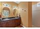 Bathroom featuring a dual sink vanity with black marble countertops, vanity lighting, and a walk-in shower at 1567 Monarch Dr, Venice, FL 34293