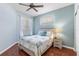Cozy bedroom with a queen bed, ceiling fan, wood floors and natural light streaming through sheer curtains at 1567 Monarch Dr, Venice, FL 34293