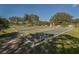 View of the community bocce ball court with manicured landscaping and mature trees on a clear day at 1567 Monarch Dr, Venice, FL 34293