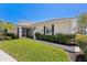 Well-maintained single-story home with lush landscaping, well manicured lawn and a screen door entrance at 1567 Monarch Dr, Venice, FL 34293