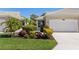 Charming single-story home showcasing its manicured lawn, well-maintained landscaping, and two car garage at 1567 Monarch Dr, Venice, FL 34293