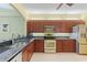 Modern kitchen with stainless steel appliances, dark wood cabinets, and granite countertops at 1567 Monarch Dr, Venice, FL 34293