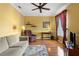Comfortable living room featuring a ceiling fan, a sofa, an armchair, and hardwood floors with a decorative rug at 1567 Monarch Dr, Venice, FL 34293