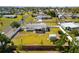 Aerial view of a fenced property with a well-maintained lawn and a storage shed in a residential neighborhood at 1600 Maryknoll Rd, Englewood, FL 34223