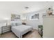 Bright bedroom with two windows, neutral color palette, light wood floors, and comfortable chair at 1600 Maryknoll Rd, Englewood, FL 34223