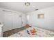 Bedroom featuring a sliding closet door, window, laminate flooring, and white walls at 1600 Maryknoll Rd, Englewood, FL 34223