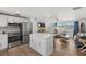 Open concept kitchen with white cabinets, stainless appliances, breakfast bar, and view to living area at 1600 Maryknoll Rd, Englewood, FL 34223