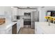 Kitchen featuring stainless steel appliances, white cabinets, breakfast bar, and quartz countertops at 1600 Maryknoll Rd, Englewood, FL 34223