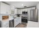 Bright kitchen features white cabinets, stainless steel appliances and quartz countertops at 1600 Maryknoll Rd, Englewood, FL 34223