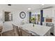 Bright kitchen featuring white cabinets, stainless appliances, breakfast bar, and sliding glass door to patio at 1600 Maryknoll Rd, Englewood, FL 34223