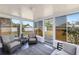 Enclosed sun room with wicker furniture, large windows, and view of the backyard at 1600 Maryknoll Rd, Englewood, FL 34223