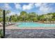 Large community pool featuring lounge chairs, umbrellas, and mature trees for a resort-style living at 16258 Hidden Oak Loop, Bradenton, FL 34211