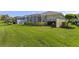 Expansive lawn, lush green backyard with a screened-in lanai, and mature landscaping at 1627 Lancashire Dr, Venice, FL 34293