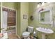 Bathroom with pedestal sink, floral wallpaper, and walk-in shower at 1627 Lancashire Dr, Venice, FL 34293