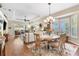 Sun-drenched living space with hardwood floors, ceiling fan and a seamless flow to the dining area at 1627 Lancashire Dr, Venice, FL 34293
