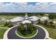 Aerial shot of the Pelican Pointe clubhouse with circular drive, flags, and manicured landscaping at 1717 Dogleg Dr, Venice, FL 34285