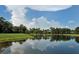 A serene pond reflects the trees and sky of the surrounding golf course at 1717 Dogleg Dr, Venice, FL 34285