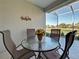 Patio dining table with potted flowers overlooking pond at 1808 San Silvestro Dr, Venice, FL 34285