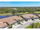 Beautiful aerial view of villa homes overlooking a lake and golf course, complemented by mature trees at 1853 San Silvestro Dr, Venice, FL 34285