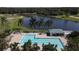 Aerial view of the pool and surrounding area, with trees, chairs, and golf course at 1853 San Silvestro Dr, Venice, FL 34285