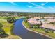 Aerial view showcasing waterfront homes along a canal, adjacent to a lush golf course at 1853 San Silvestro Dr, Venice, FL 34285