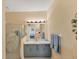 Bathroom featuring gray cabinets, granite countertops, and a glass-enclosed shower with a palm tree design at 1853 San Silvestro Dr, Venice, FL 34285