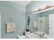 This cozy bathroom features a decorative light fixture, artwork, and a shower with tub at 1853 San Silvestro Dr, Venice, FL 34285