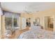 Comfortable bedroom with wood floors, a ceiling fan, and a view to a screened lanai at 1853 San Silvestro Dr, Venice, FL 34285