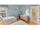 This coastal style bedroom features twin beds, wicker furniture, and a light blue wall color at 1853 San Silvestro Dr, Venice, FL 34285