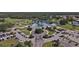 Aerial view showcasing a clubhouse with extensive parking, manicured grounds, and a serene lake at 1853 San Silvestro Dr, Venice, FL 34285