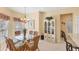 Bright dining area with glass-top table, floral-patterned chairs, and elegant chandelier lighting at 1853 San Silvestro Dr, Venice, FL 34285