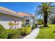 An inviting exterior view of the home showing tile roof, tropical landscaping and a well manicured lawn at 1853 San Silvestro Dr, Venice, FL 34285