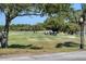 Golf course view with mature shade trees and golf carts on the fairway at 1853 San Silvestro Dr, Venice, FL 34285