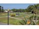 Scenic view of golf course fairway with mature trees and golf carts at 1853 San Silvestro Dr, Venice, FL 34285