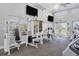 Well-equipped gym with modern weight machines, mirrored walls, large windows, and televisions for an enhanced workout experience at 1853 San Silvestro Dr, Venice, FL 34285