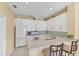 Bright kitchen features white cabinets, stainless appliances, and eat-in bar at 1853 San Silvestro Dr, Venice, FL 34285