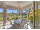 Enclosed lanai with ceiling fan and view of lake and landscaping at 1853 San Silvestro Dr, Venice, FL 34285