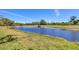 A serene pond surrounded by green grass and trees under a clear blue sky at 1853 San Silvestro Dr, Venice, FL 34285