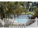 Scenic view of pool with lush tropical landscaping and lake backdrop creating a serene and resort-like atmosphere at 1853 San Silvestro Dr, Venice, FL 34285