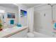 Bathroom with white vanity, ocean art and a shower/tub combination with white tile at 200 Park N Blvd # 108, Venice, FL 34285