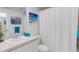 Bathroom featuring white vanity with sink, a framed ocean print, and a white shower curtain at 200 Park N Blvd # 108, Venice, FL 34285