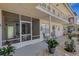 Exterior view of condo building with patios, gravel landscaping, and access to shared outdoor space at 200 Park N Blvd # 108, Venice, FL 34285